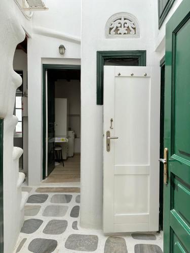 a hallway with a white door and a green door at CaN-CaN in Mikonos