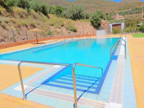une grande piscine d'eau bleue et des escaliers. dans l'établissement Casa Rural El Albergue, à Beires