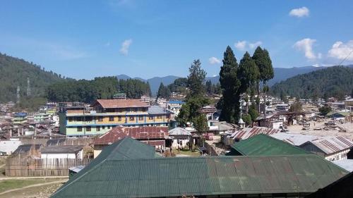 una pequeña ciudad con casas y montañas en el fondo en Arunachal Guest house, en Hāpoli