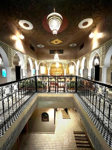 an empty building with a staircase and a chandelier at Riad Merzouga Dunes in Merzouga