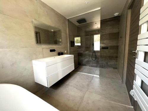 une salle de bain avec un lavabo blanc et une douche dans l'établissement Villa Mangenie, à Valbonne