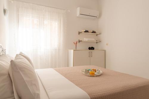 a white room with a bed with a bowl of fruit at Elio A 1BDR Apt with Garden 1 min from the beach by Hospi in Heraklio Town