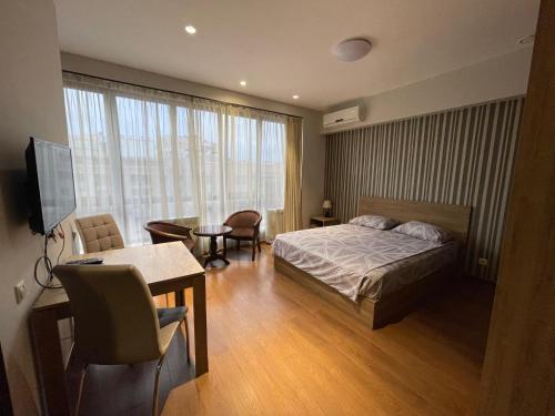 a bedroom with a bed and a desk and a table at Apartment in Yerevan City Center Republic Square Self Check-In in Yerevan