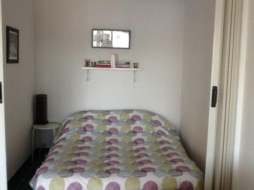 a bedroom with a bed with a colorful comforter at Isis in La Grande-Motte