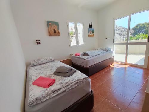two beds in a room with a window at Casa Mar in Águilas