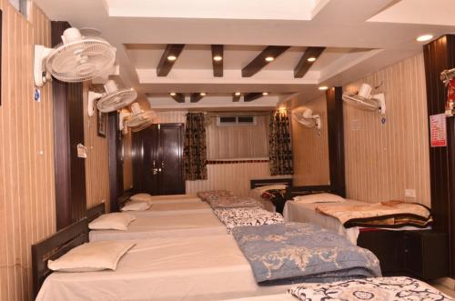 a group of beds in a room with a room with at Hotel Comfort Hostel Charbagh Inn Lucknow in Lucknow