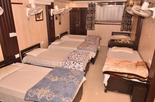 a group of four beds in a room at Hotel Comfort Hostel Charbagh Inn Lucknow in Lucknow