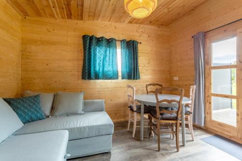 a living room with a couch and a table at Chalet 4 pers Landeleau 2kms canal in Landeleau