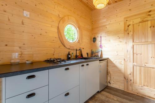 a kitchen with white cabinets and a window at Chalet 4 pers Landeleau 2kms canal in Landeleau