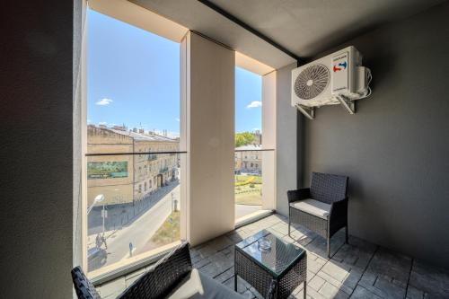 a room with a large window with a table and a fan at FORUM apart in Lviv
