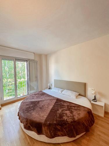a bedroom with a large bed with a large window at Clauhomes Suite de Mozart in Tarragona
