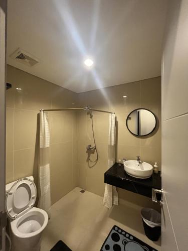 a bathroom with a toilet and a sink at DeAr Caspian Grand Sunkono Lagoon Apartment in Surabaya