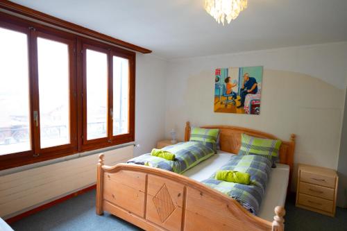 a bedroom with a wooden bed with two pillows at City Center Holiday Apartment in Interlaken