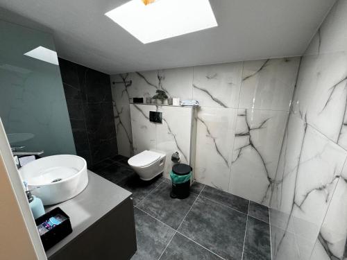 a bathroom with a white toilet and a sink at Villa Sunset Yerakini in Poligiros