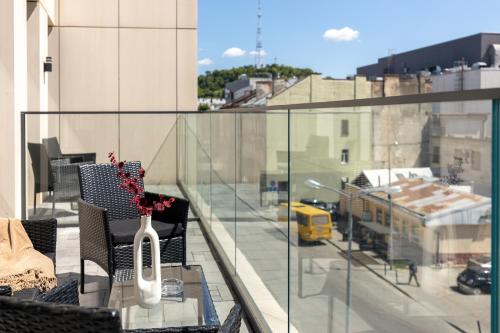 a glass balcony with a vase on a table at FORUM apart in Lviv