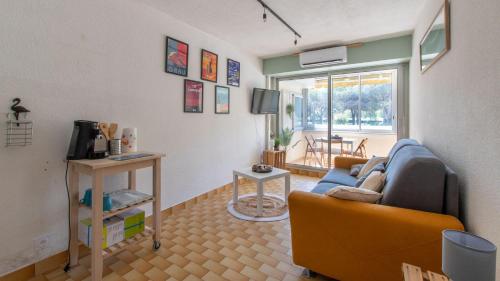 un salon avec un canapé et une télévision dans l'établissement LA LAGUNE -105- Studio cabine 4 pers, au Grau-du-Roi