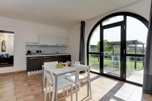 een keuken en eetkamer met een witte tafel en stoelen bij Residence Fontanelle in Cavaion Veronese