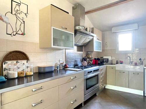 Il comprend une cuisine équipée d'une cuisinière. four supérieur à côté d'un évier dans l'établissement LE BULTOIR, à Pornic