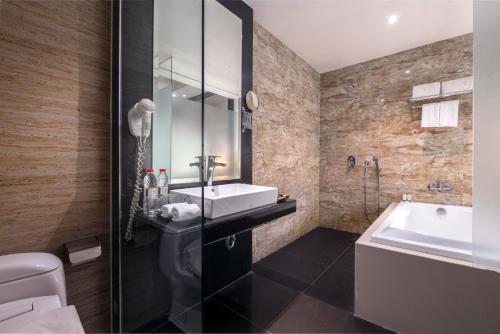 łazienka z umywalką, toaletą i wanną w obiekcie Gets Hotel Semarang w mieście Semarang