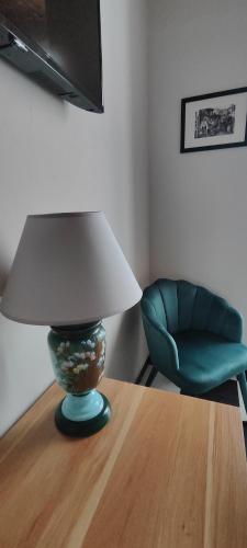 a lamp on a table next to a green chair at Antica Dogana in Sarzana