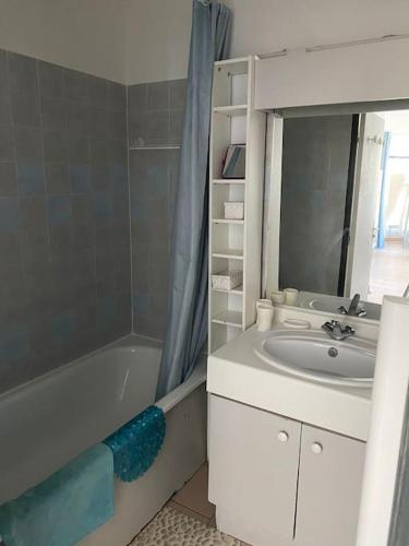 une salle de bain avec un lavabo, une baignoire et un miroir dans l'établissement Appartement T2+cabine dans résidence au cap d’Agde, au Cap d'Agde