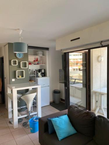 un salon avec un canapé et une cuisine dans l'établissement Appartement T2+cabine dans résidence au cap d’Agde, au Cap d'Agde