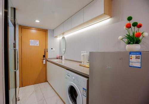 上海的住宿－客堂涧公寓酒店，厨房配有洗衣机和冰箱。
