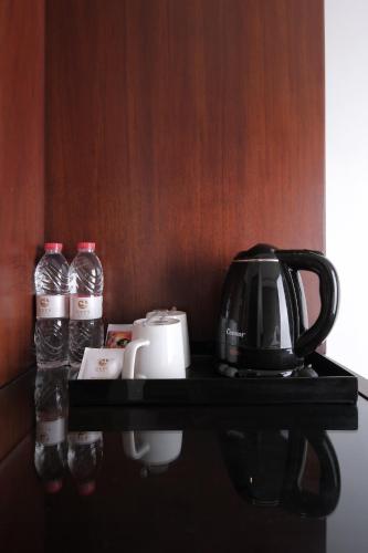 a black shelf with a coffee maker and water bottles at Gets Premiere Semarang in Semarang