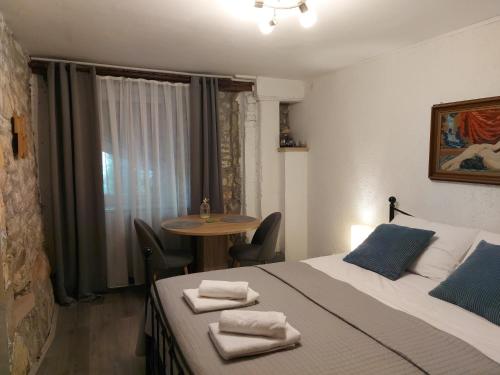 Una habitación con una cama y una mesa con toallas. en Apartment Balinovaca en Skradin