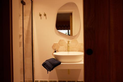 uma casa de banho com um lavatório e um espelho em The Old Winery Cottage No2 em Shepton Mallet