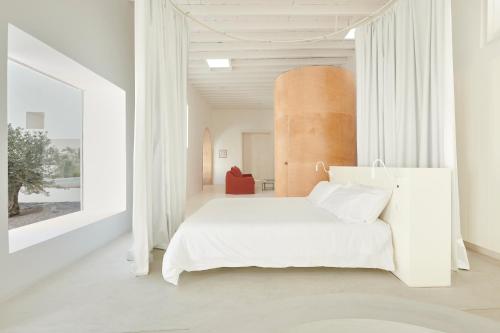 a bedroom with a white bed and a large window at Casa Montelongo - Adults Only in La Oliva