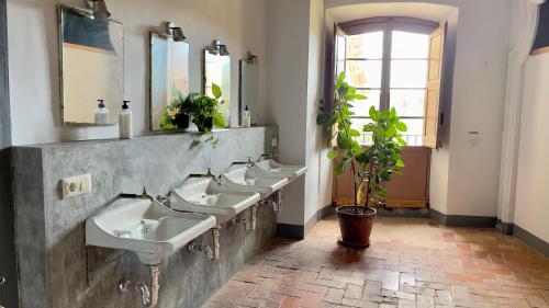 a bathroom with four sinks and a row of mirrors at Can Traver de Besalú in Maia de Montcal