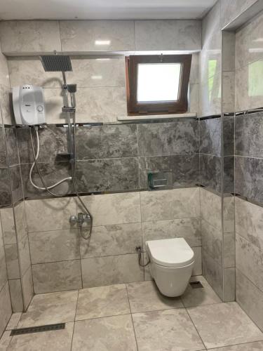 łazienka z prysznicem, toaletą i oknem w obiekcie Yeşil ve huzur dolu bir daire w mieście Bulancak