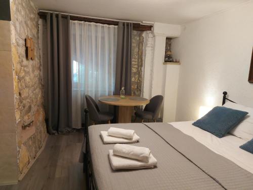 a hotel room with two beds and a table at Apartment Balinovaca in Skradin