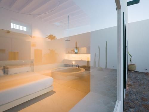 a bedroom with a bed and a tub in a room at Casa Montelongo - Adults Only in La Oliva