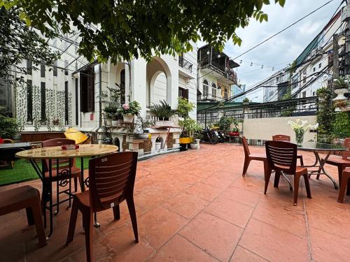 a patio with tables and chairs in a courtyard at Tuna Homestay Hanoi & Experience in Hanoi