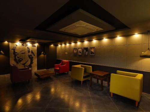 a restaurant with colorful chairs and tables in a room at Kfour Apartment & Hotels Private Limited in Madurai