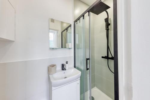a white bathroom with a sink and a shower at Le Nid Cozy - Face Gare De Corbeil in Corbeil-Essonnes