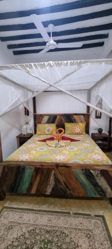 a bed in a room with a ceiling at Salama & Mbuyuni Bungalows in Matemwe