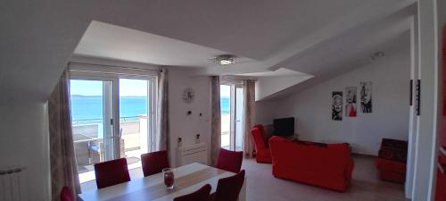 uma sala de estar com uma mesa e cadeiras vermelhas em Apartments Villa Lavanda em Zadar