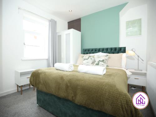 ein Schlafzimmer mit einem Bett mit zwei Kissen darauf in der Unterkunft Kerrycroy House, Great location, Contractors in Cardiff