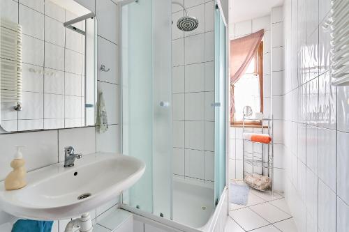 biała łazienka z umywalką i prysznicem w obiekcie Jaś i Małgosia w Szklarskiej Porębie