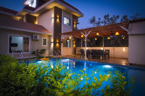 a house with a swimming pool in front of a house at Iris Villa - Nagaon Beach in Nagaon