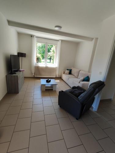 a living room with a couch and a tv at Appartement T2 cosy in Gourdon-en-quercy