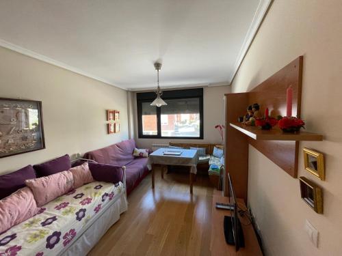 uma sala de estar com um sofá roxo e uma mesa em Amplio apartamento con Garaje em Suances