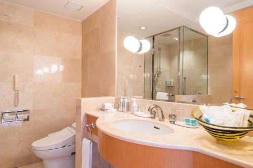 a bathroom with a sink and a toilet and a mirror at Grand Park Otaru in Otaru