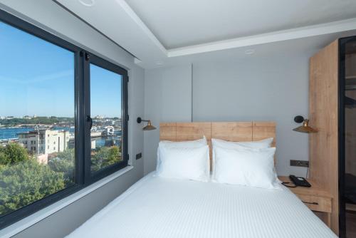 a bedroom with a bed and a large window at ART KARAKÖY in Istanbul