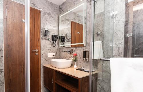 a bathroom with a sink and a shower at The Belvedere Himalayan Retreat, Mcleodganj, Dharamshala - By Leisure Hotels in McLeod Ganj