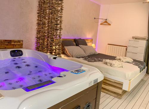 a room with a large bath tub next to a bed at Domaine de la Besnerie Gites avec SPA Privatif à 10 min du Mont St Michel in Tanis