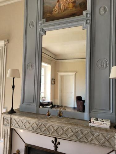a mirror over a fireplace in a living room at Marraycourt, Chateau-Chambre d'Hotes in Marcigny